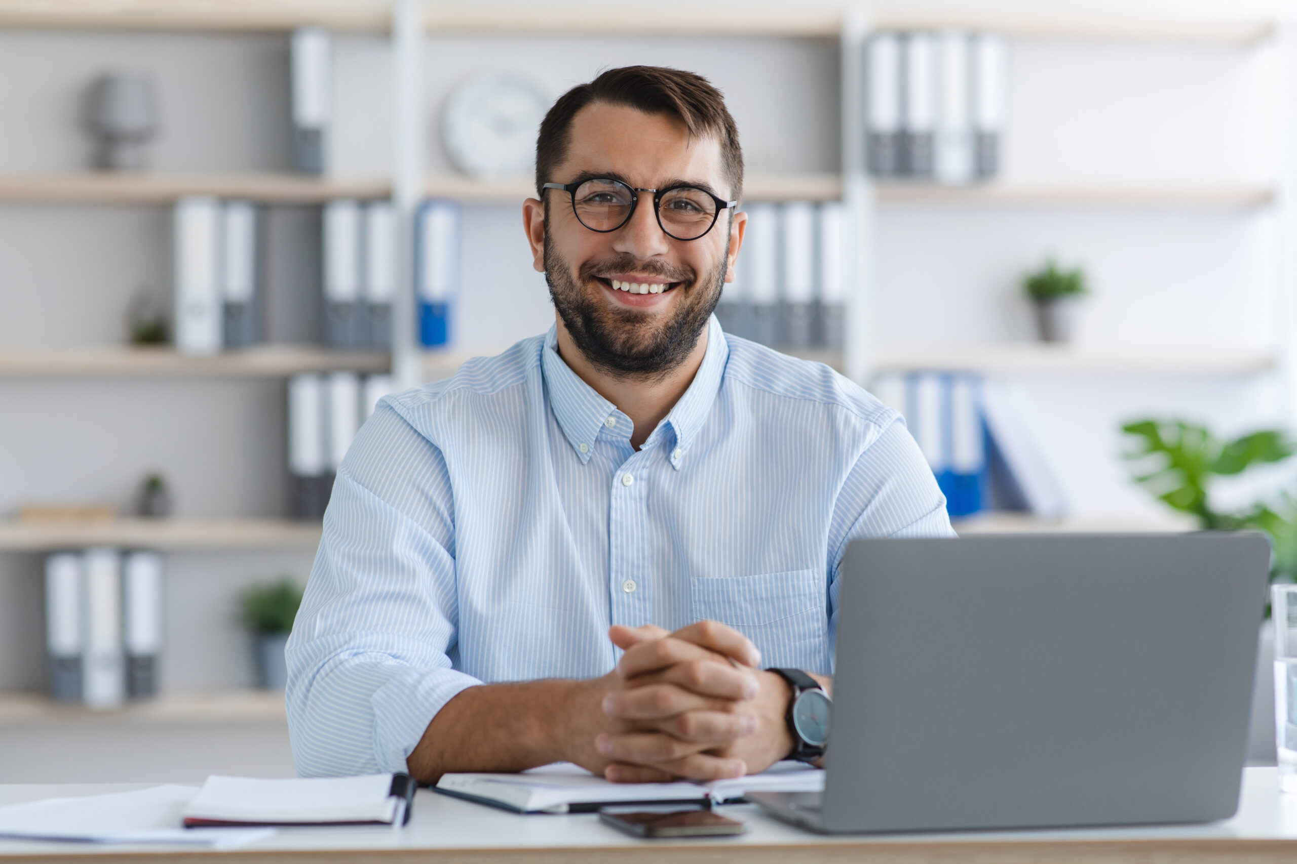 Close-up of compliance specialist working at computer at desk in office.
