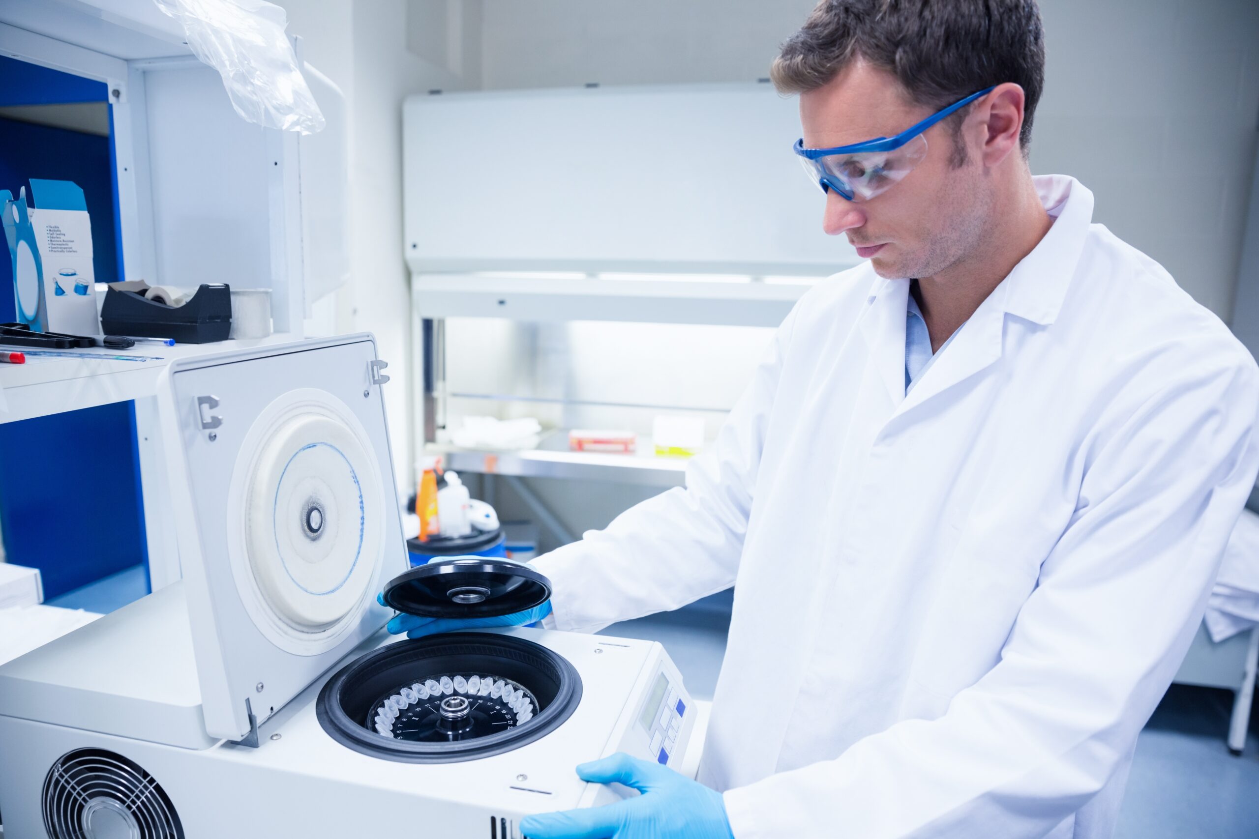 Lab technician wearing PPE and using a centrifuge