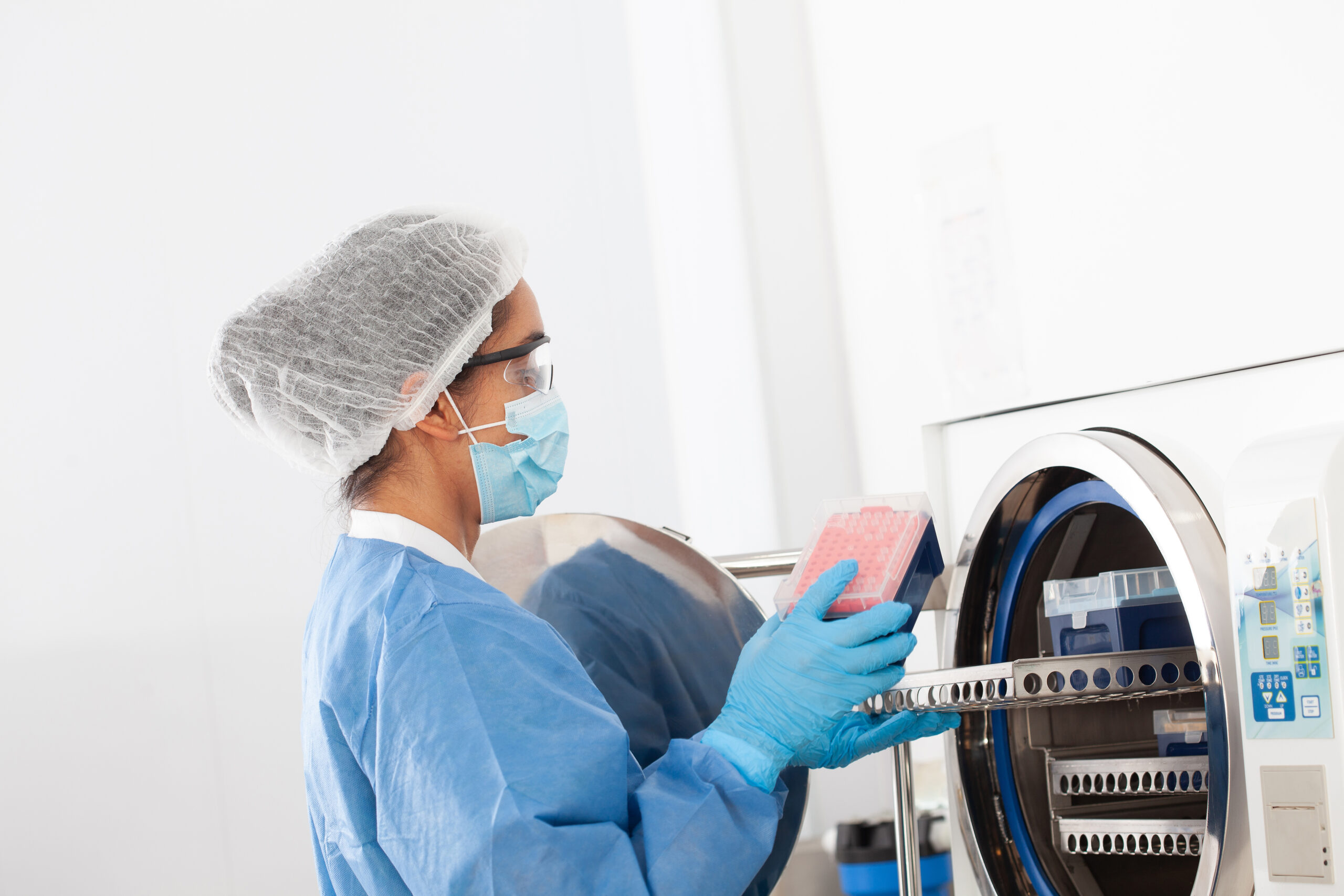 Lab operations assistant sterilizing laboratory material in autoclave